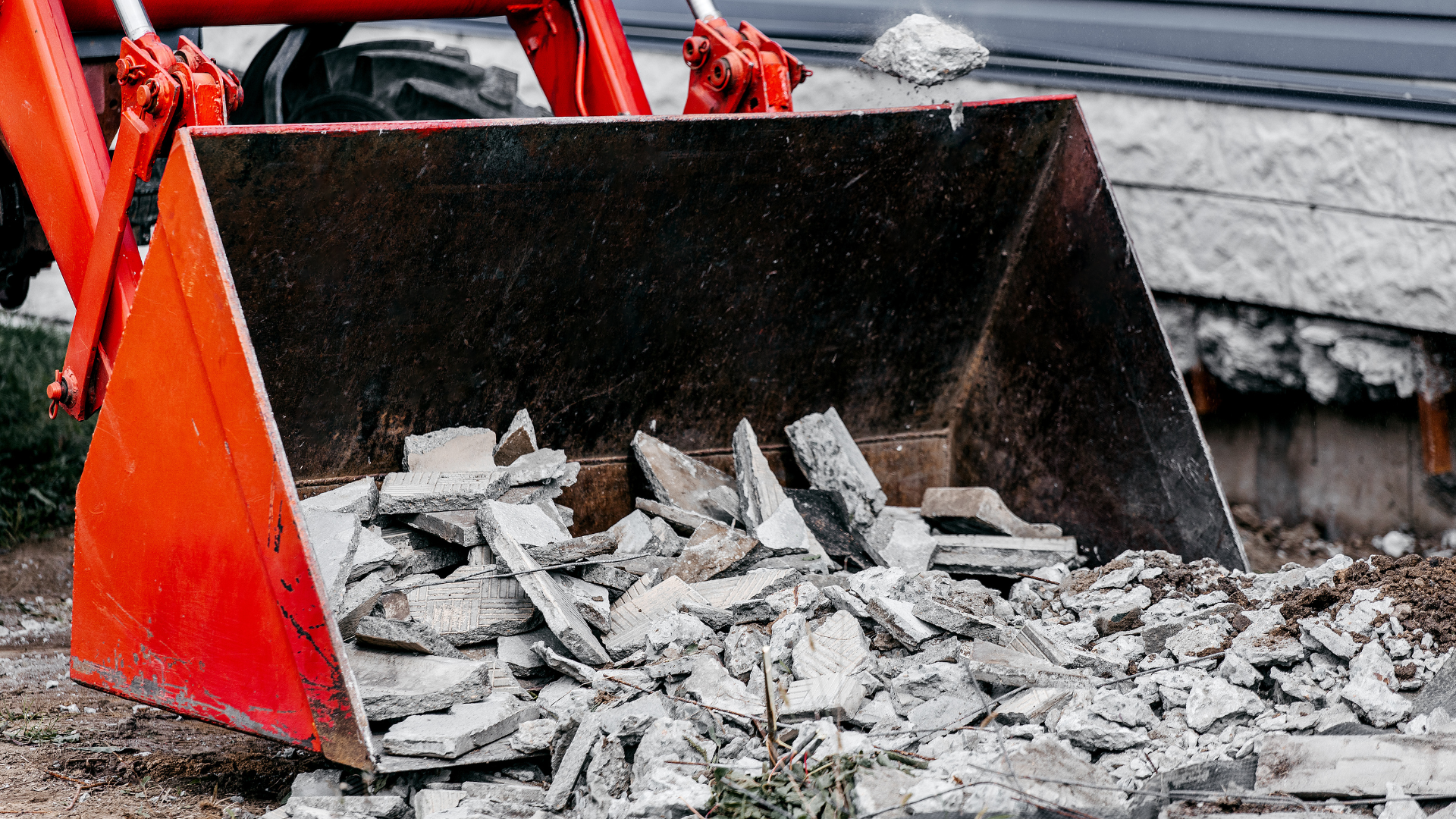 A bulldozer is loading concrete into a bucket on a construction site.