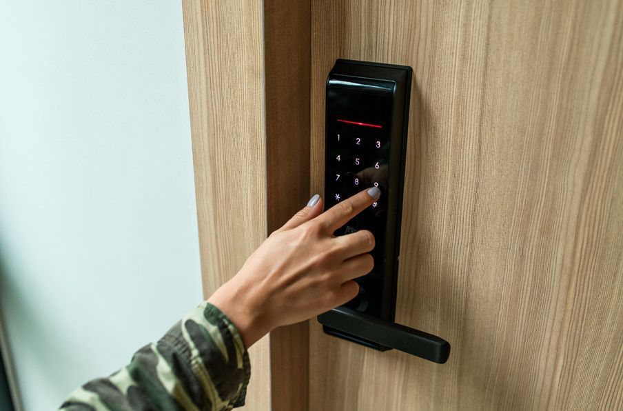 A Person is Pressing a Button on a Door Lock — ADC Locksmiths in Wollongong, NSW