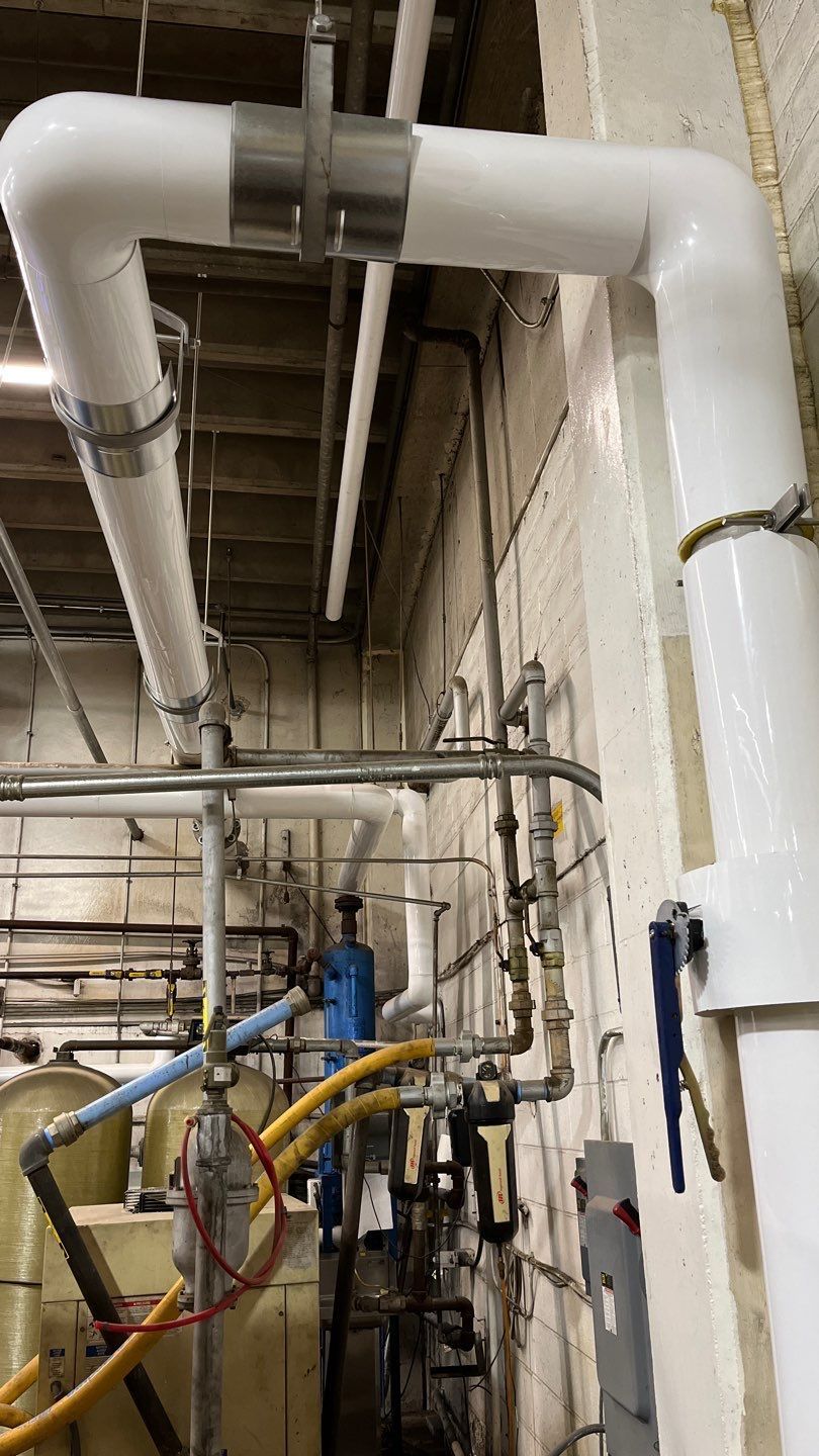 A bunch of pipes are connected to each other in a room.