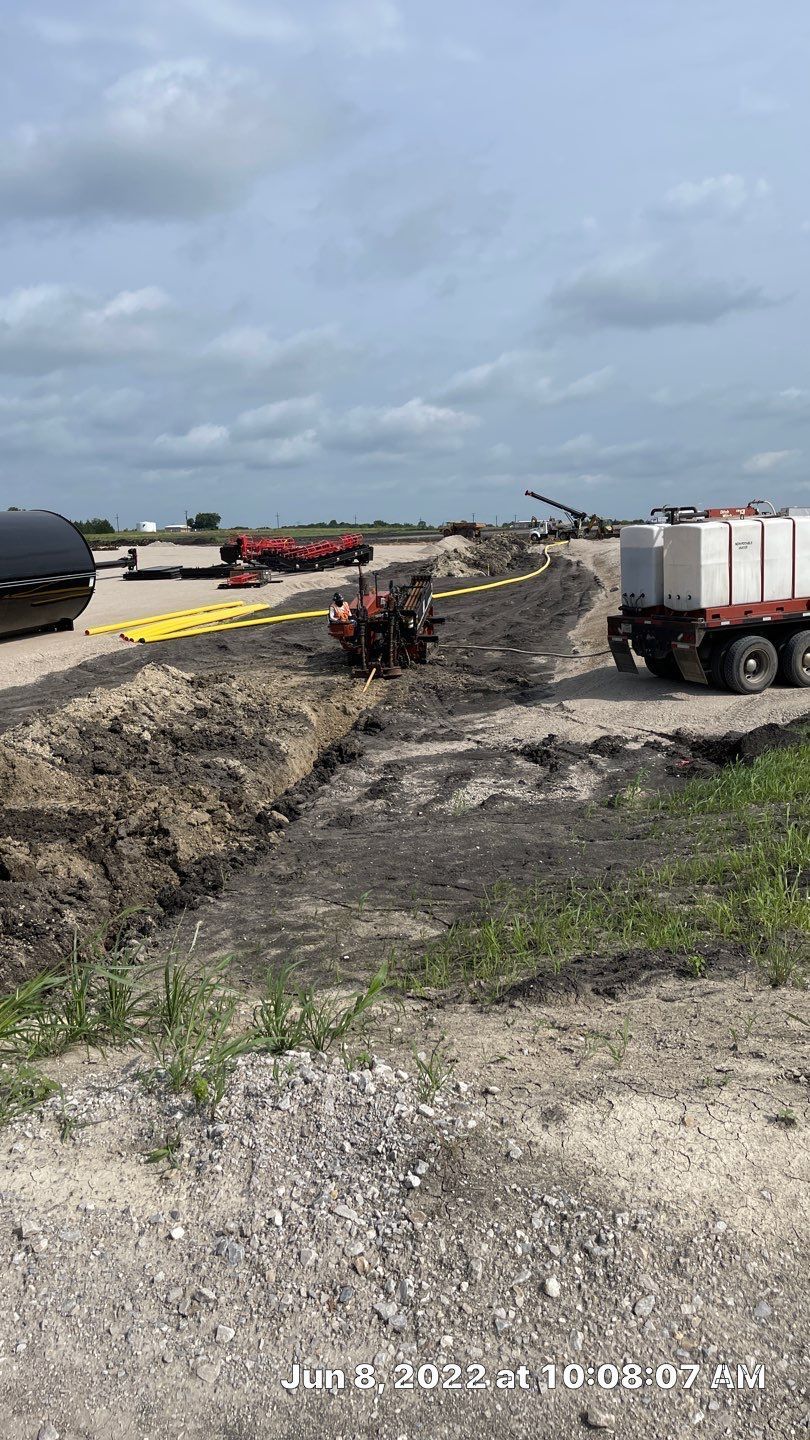 A truck is driving down a dirt road next to a large pile of dirt.