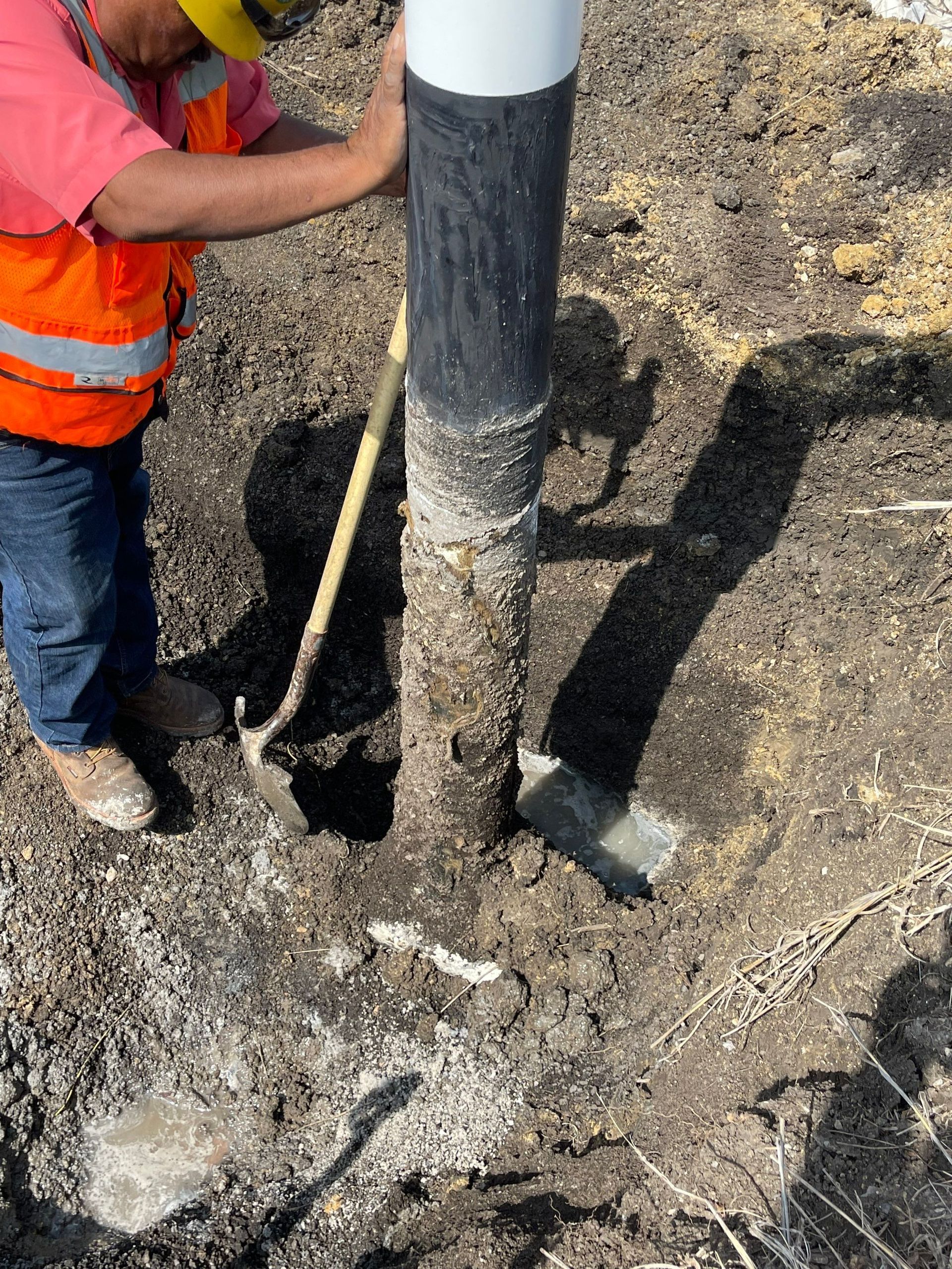 A man is digging a hole in the ground with a shovel.
