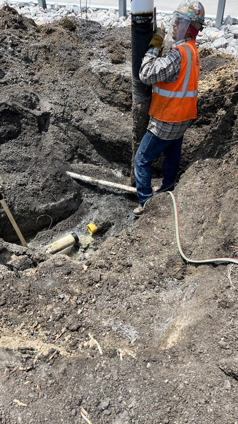 A construction worker is standing in a pile of dirt.