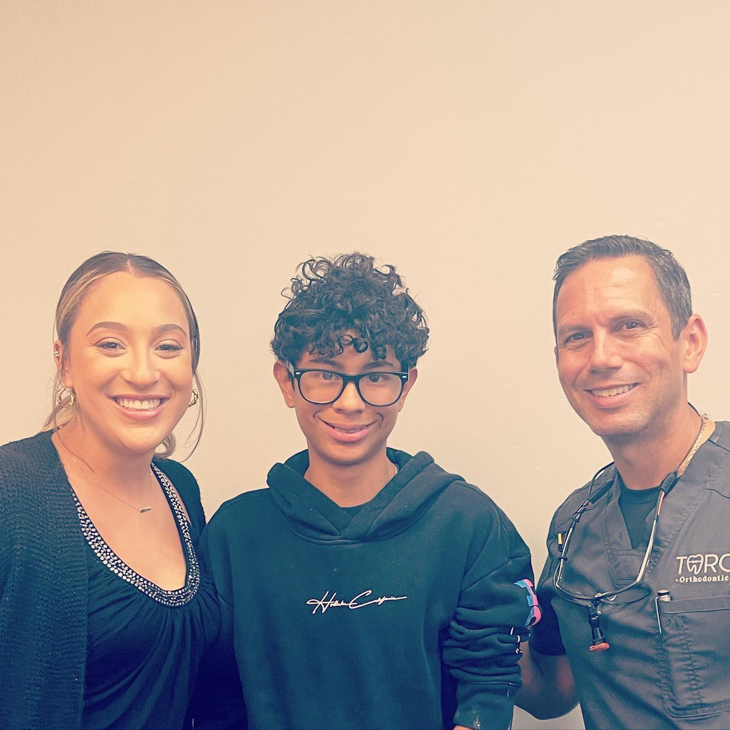 A woman and two men are posing for a picture together