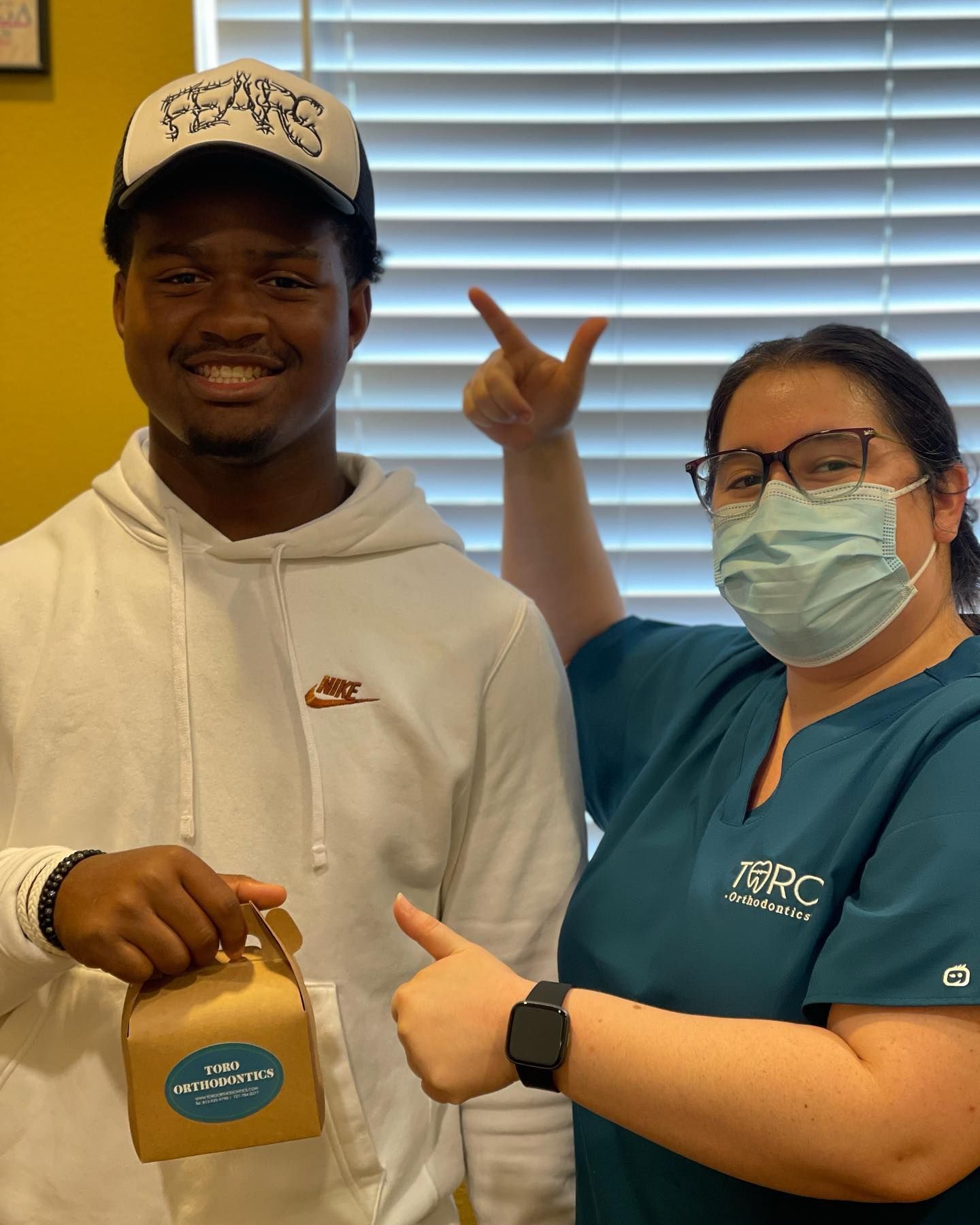 A man and a woman wearing face masks are posing for a picture.