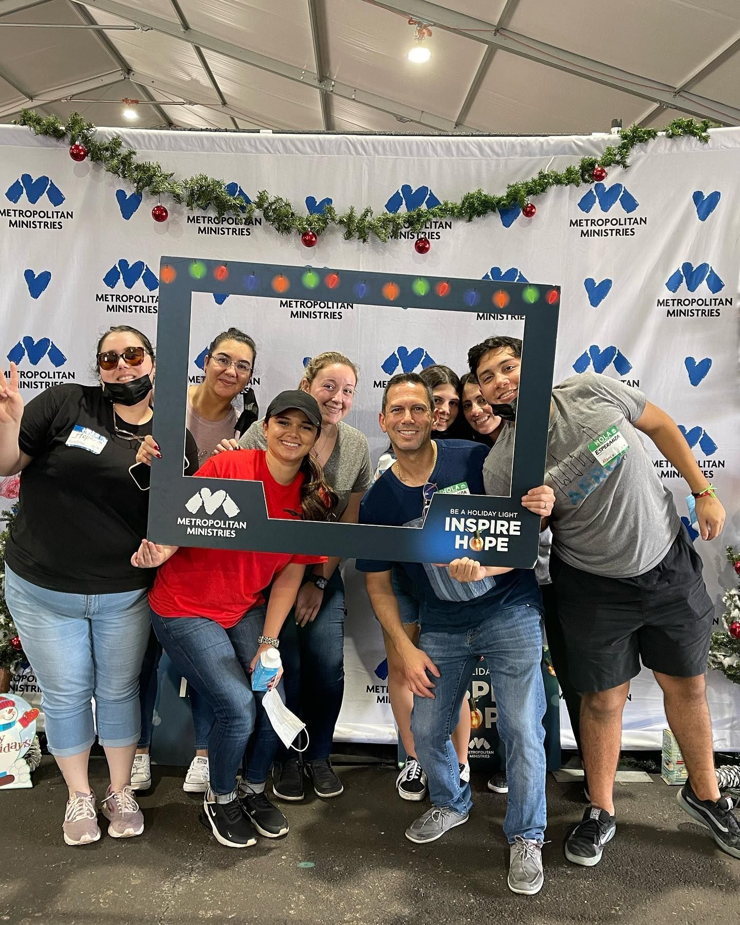 A group of people are posing for a picture with a picture frame.
