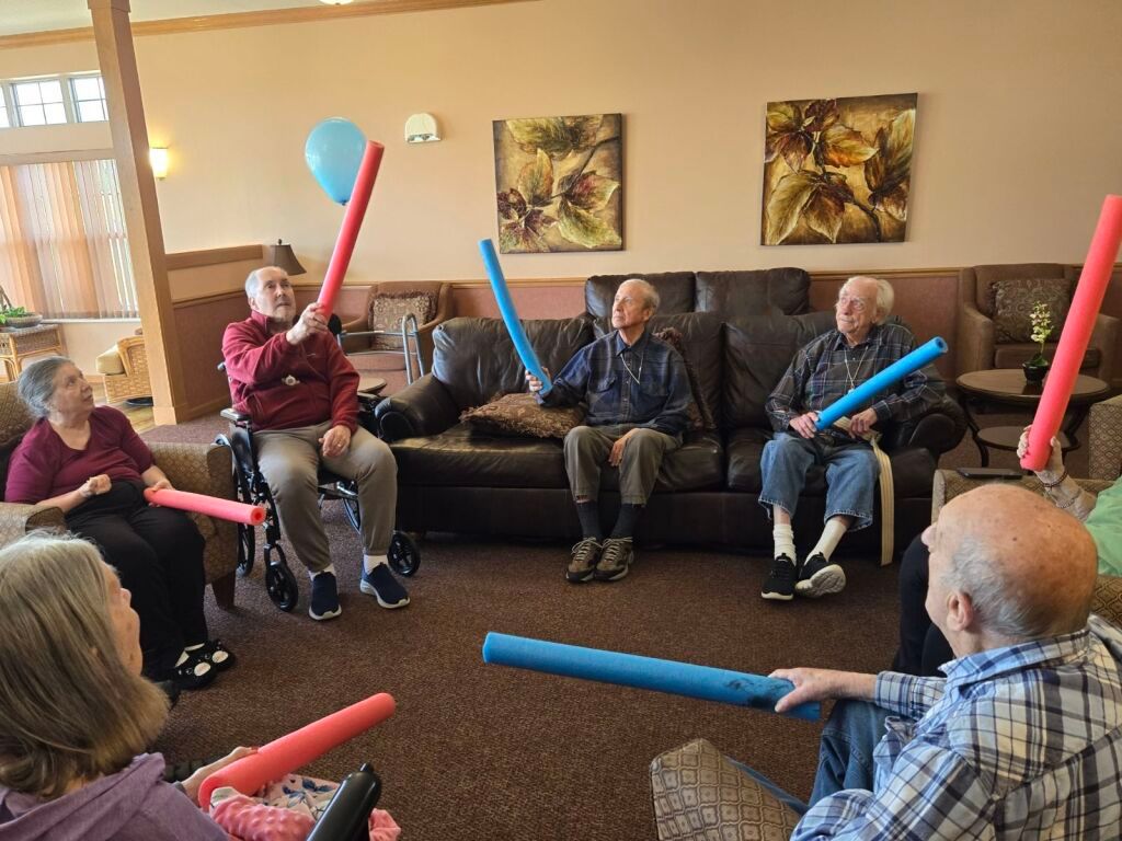 A group of elderly people are sitting in a circle talking to each other.
