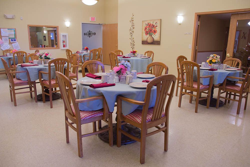 A dining room with tables and chairs set for a meal