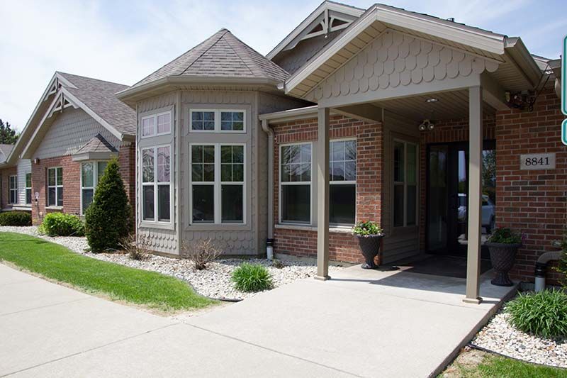 A brick house with a porch and a lot of windows