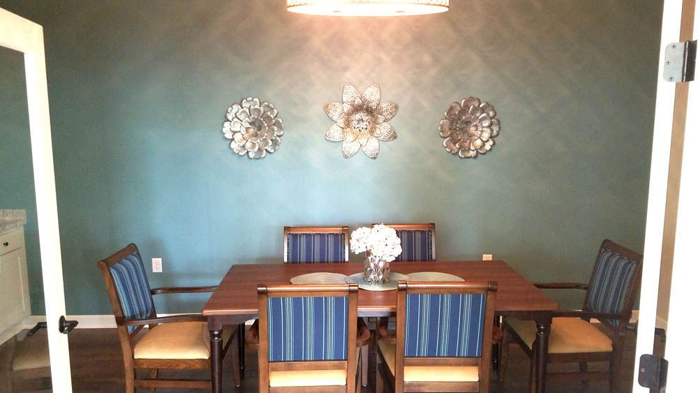 A dining room with a table and chairs and a chandelier