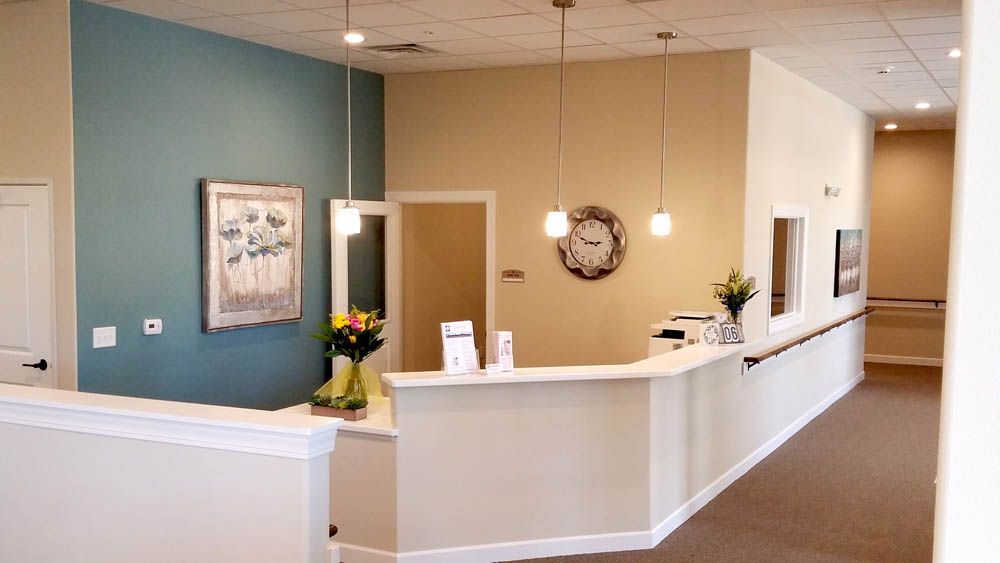 A reception area in a hospital with a clock on the wall.