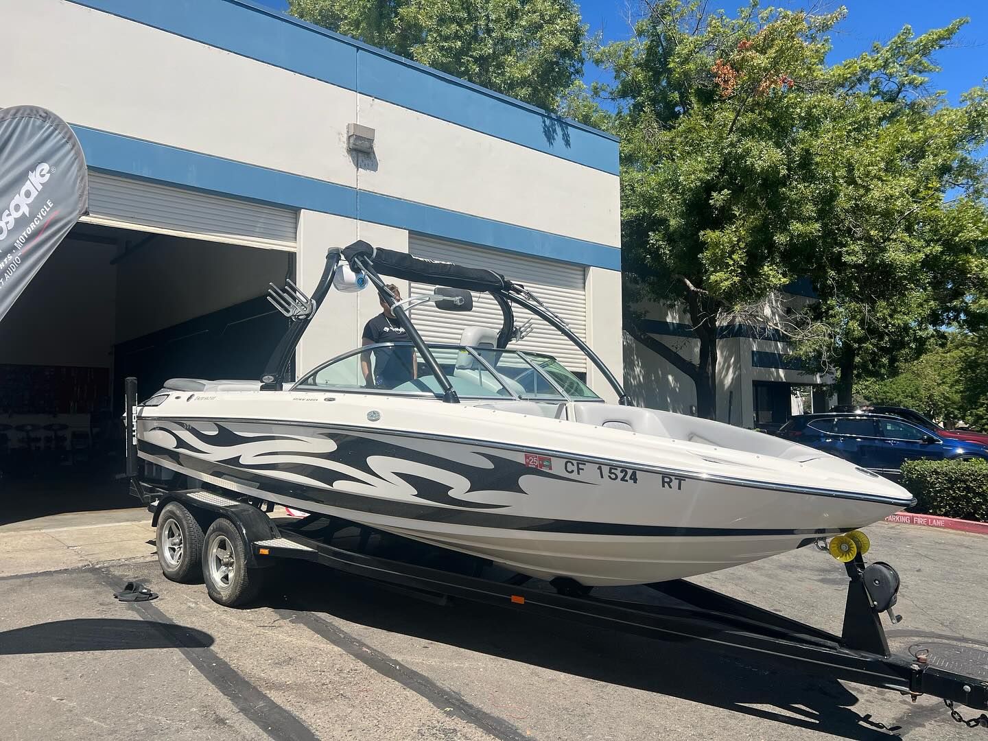 A white and black boat is parked in front of a building.