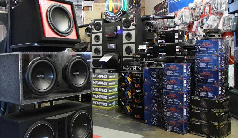 A bunch of speakers are stacked on top of each other in a store.