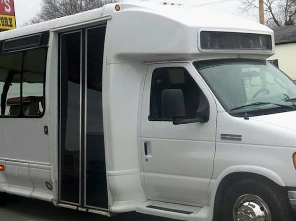 White shuttle bus with an open door parked outdoors