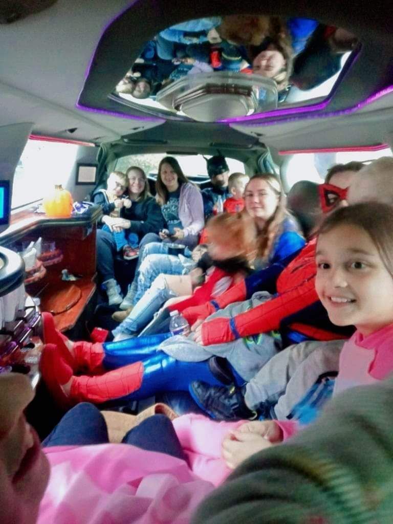 People riding together in a decorated van, smiling and posing inside.