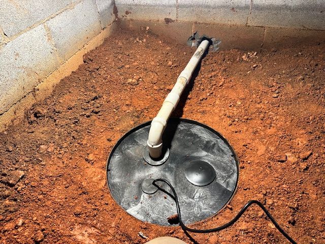 A hole in the ground with a pipe sticking out of it.