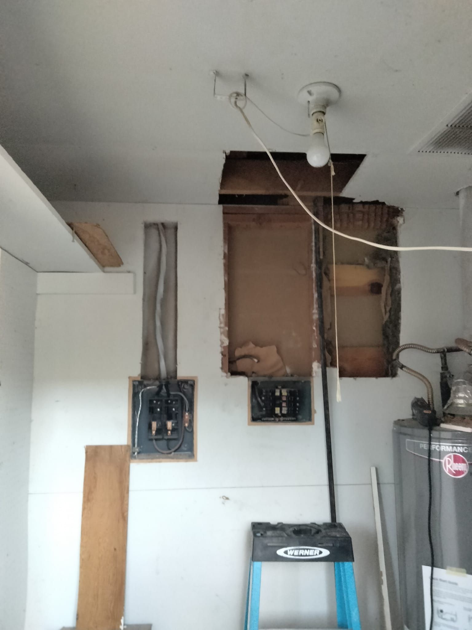 A room with a ladder and a water heater in it