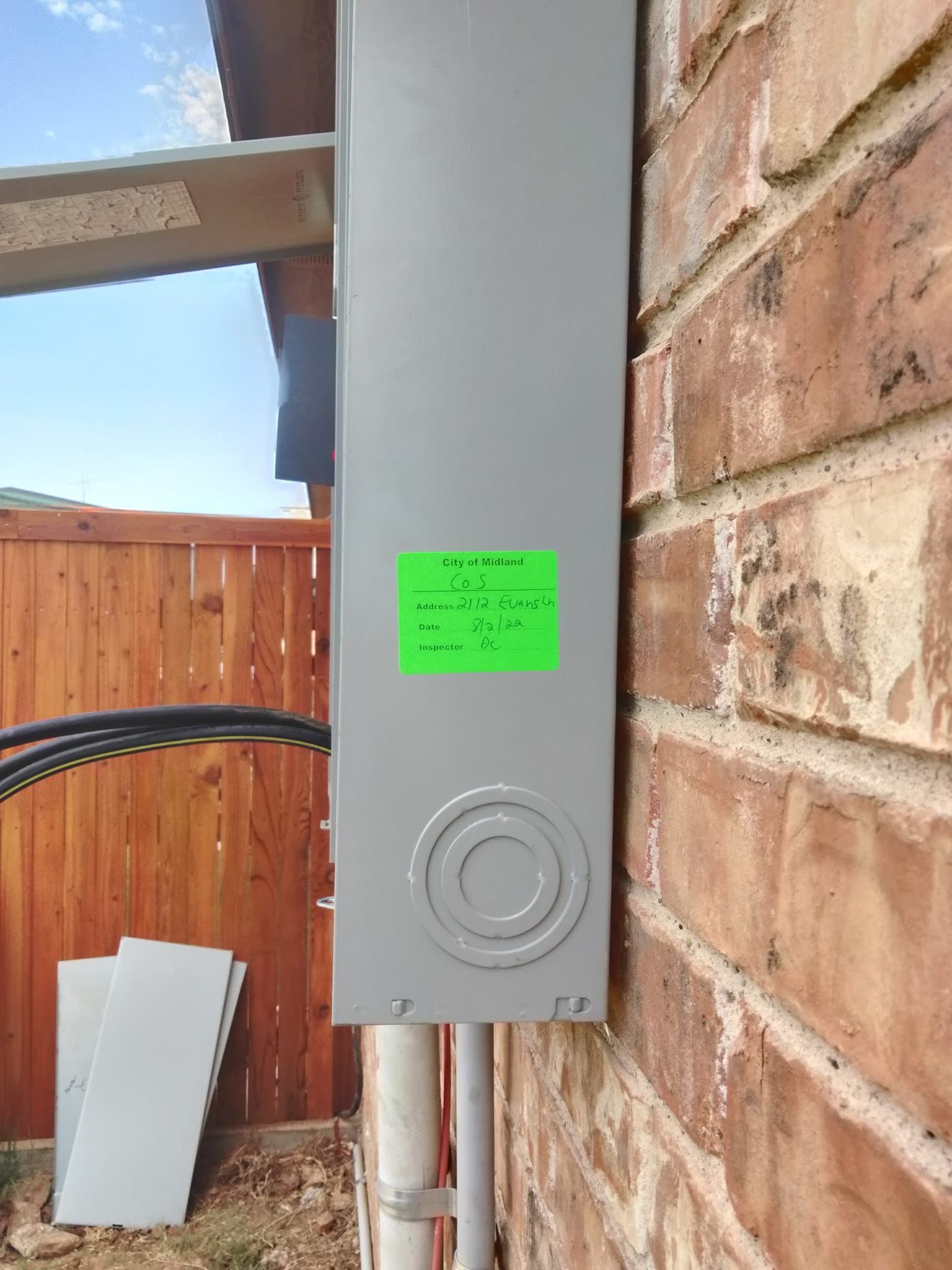 A green sticker is on the side of a brick wall.