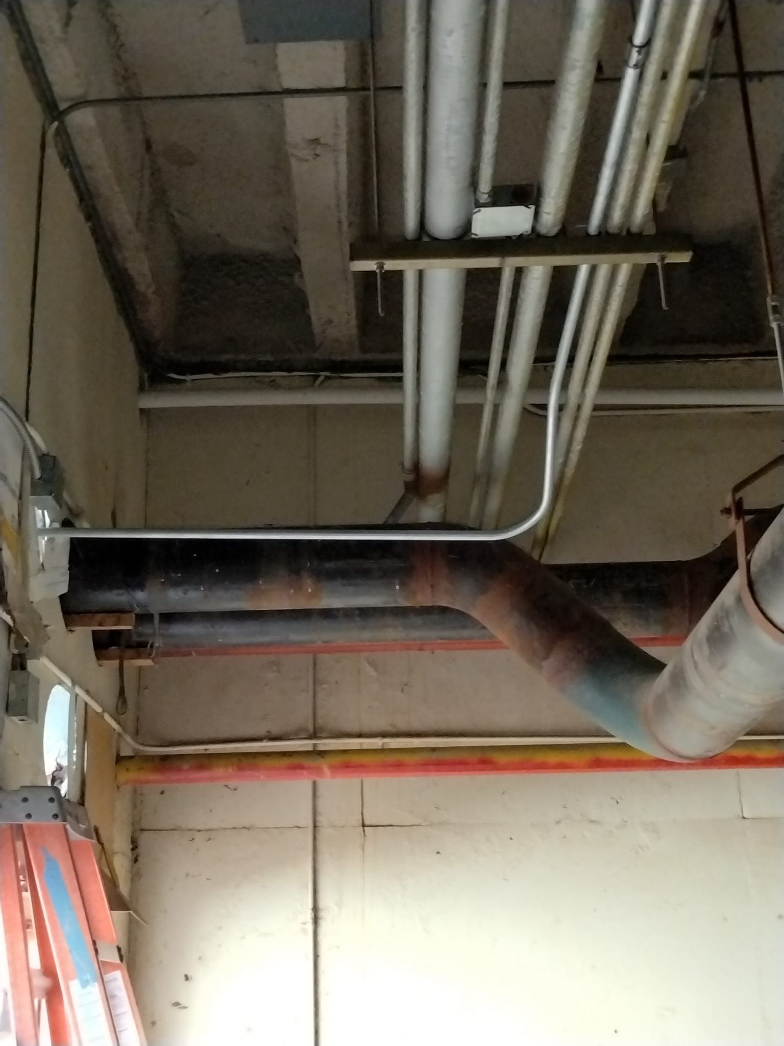 A room with a lot of pipes hanging from the ceiling