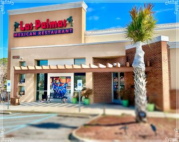 Las Palmas Mexican Restaurant exterior, beige stucco, red signage, palm tree, and wooden pergola.