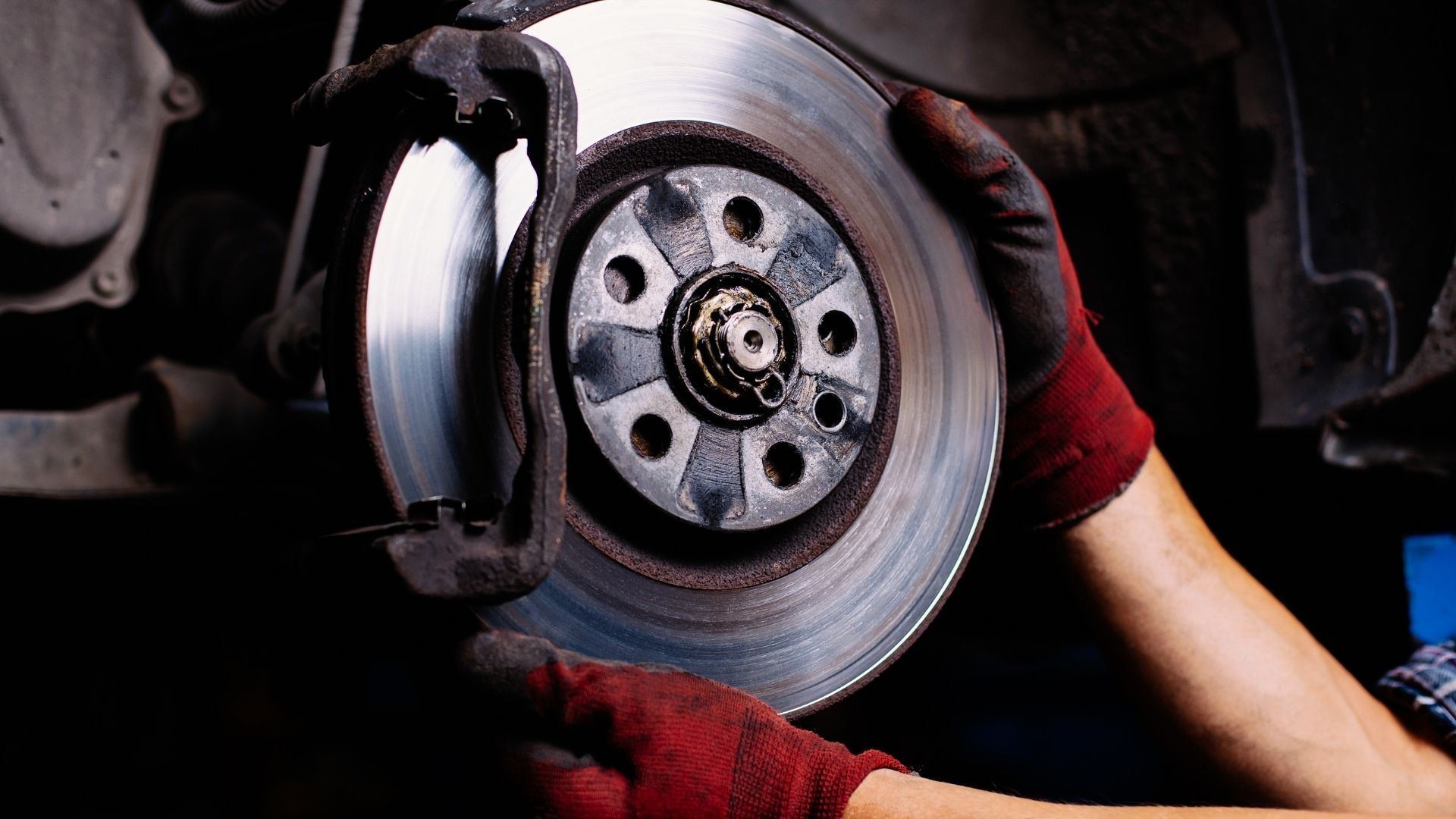 A person is fixing a brake disc on a car.