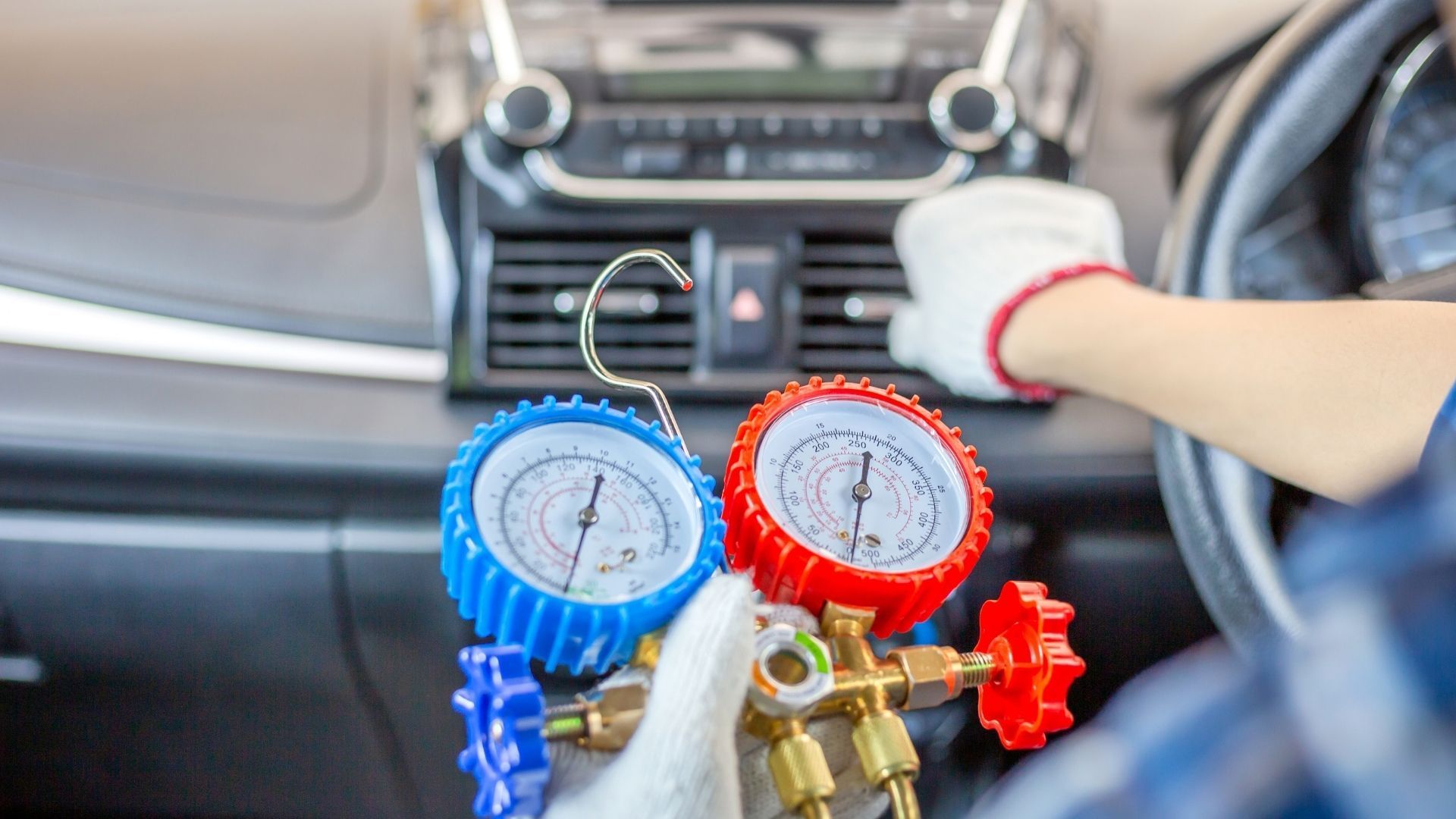 A person is working on a car air conditioning system.