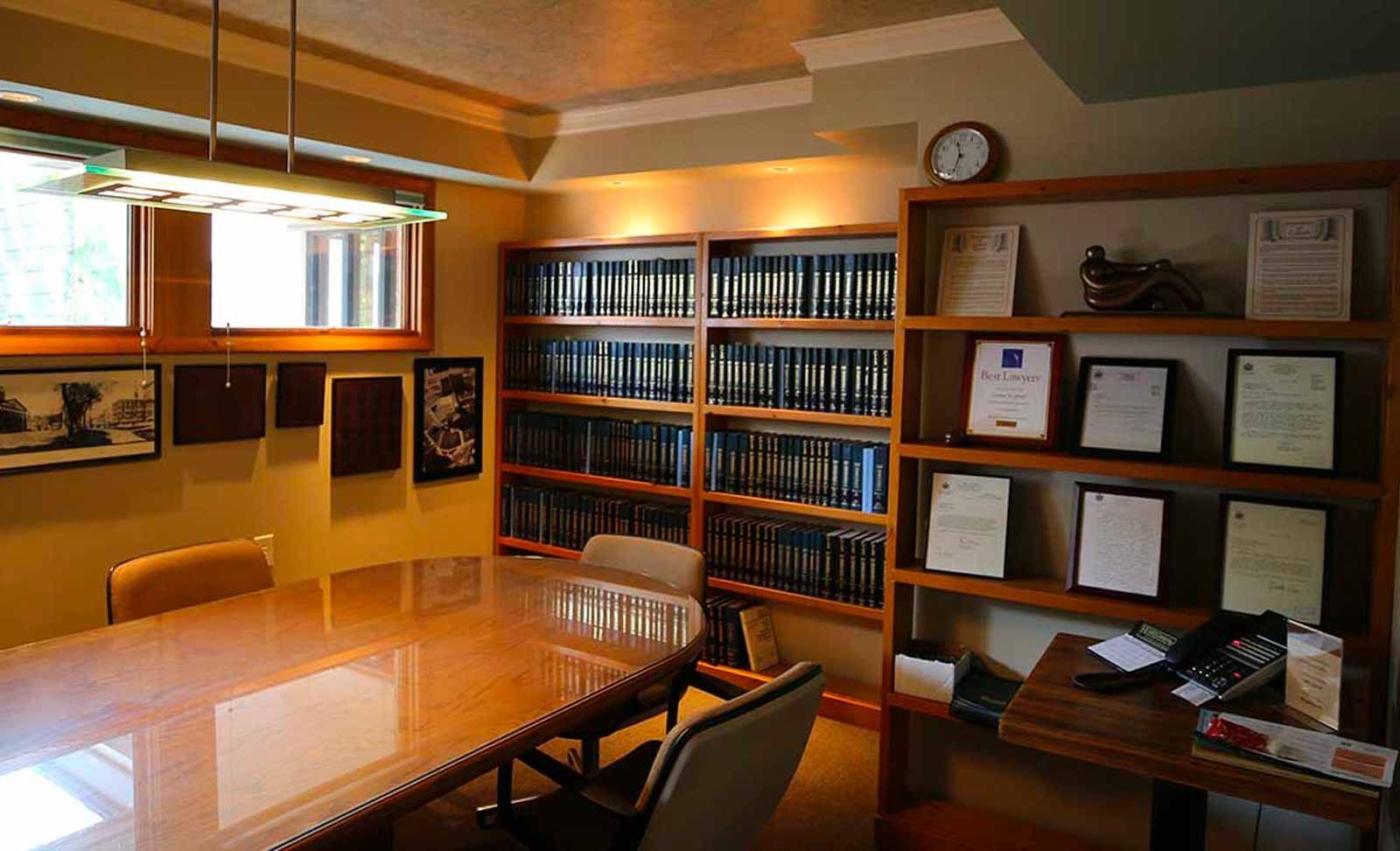 A room with a table , chairs , shelves and a clock.