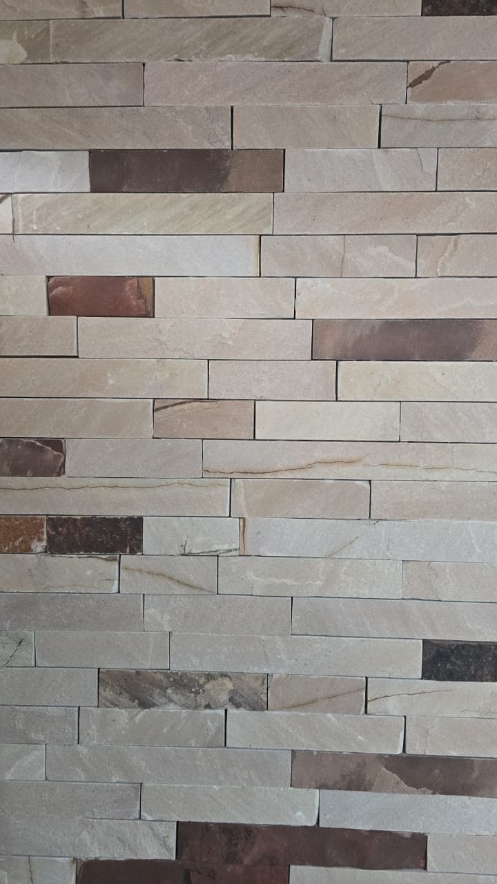 Pared de piedra gris y beige con texto “Calidad de servicio” y logo Cerro Dorado Ndebas y Lajas.