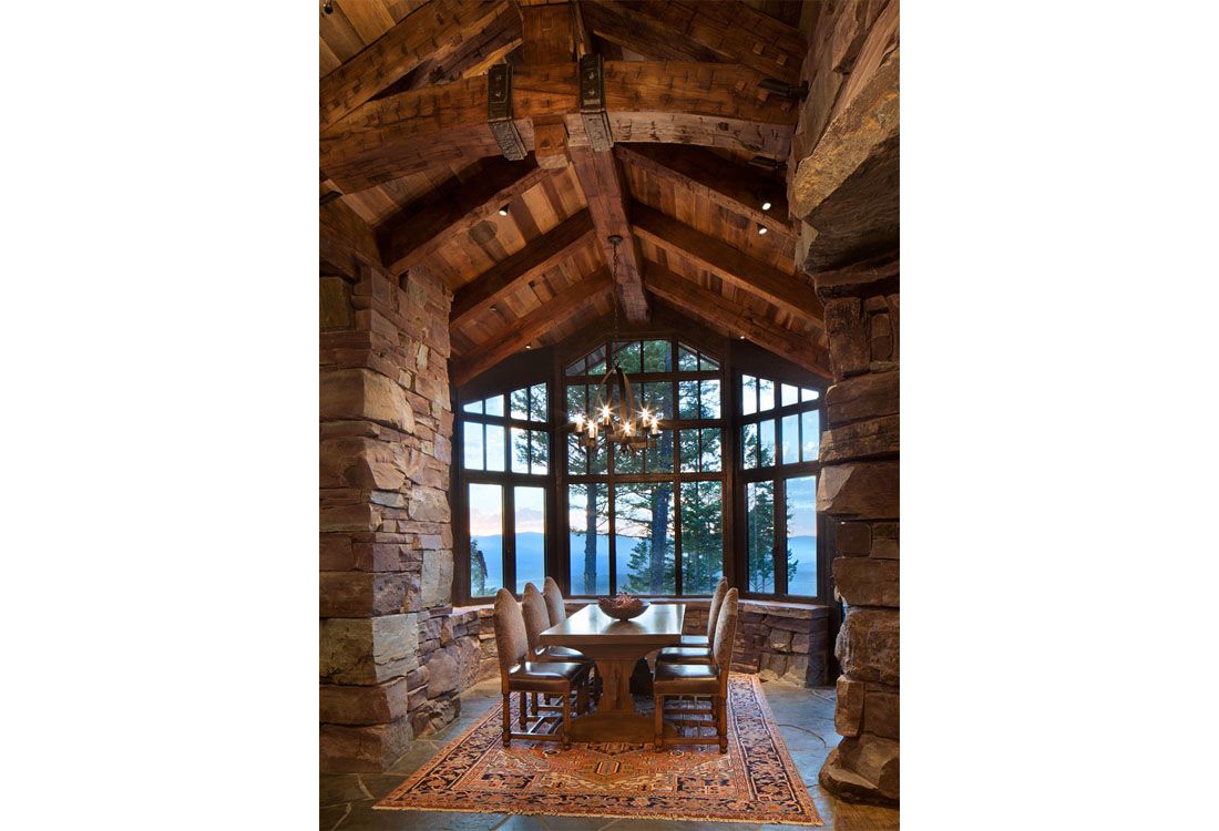A dining room with a table and chairs and a large window.