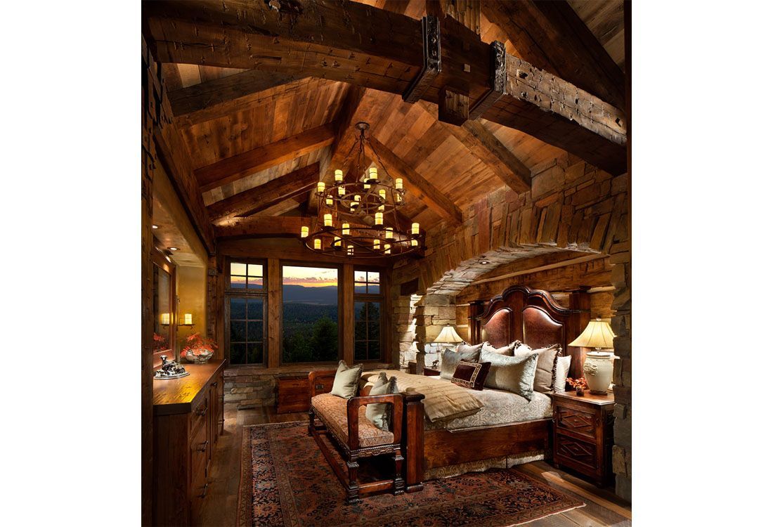 A bedroom with a bed , dresser , nightstand , and chandelier.