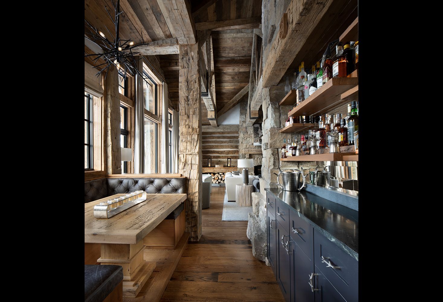 A long hallway in a house with a table and a bar.