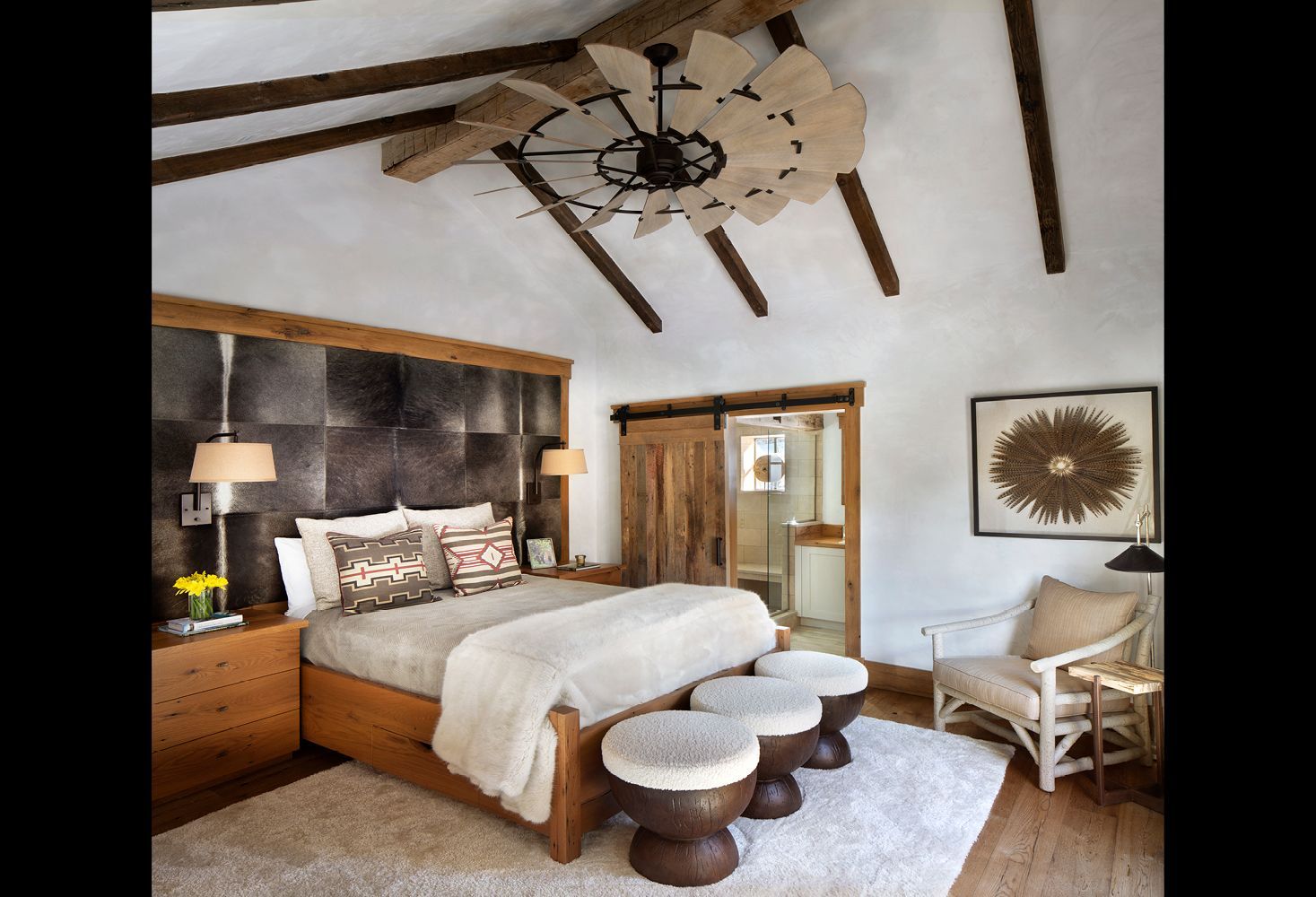 A bedroom with a large bed and a ceiling fan