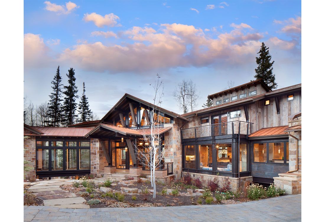 A large house with a lot of windows and trees in the background