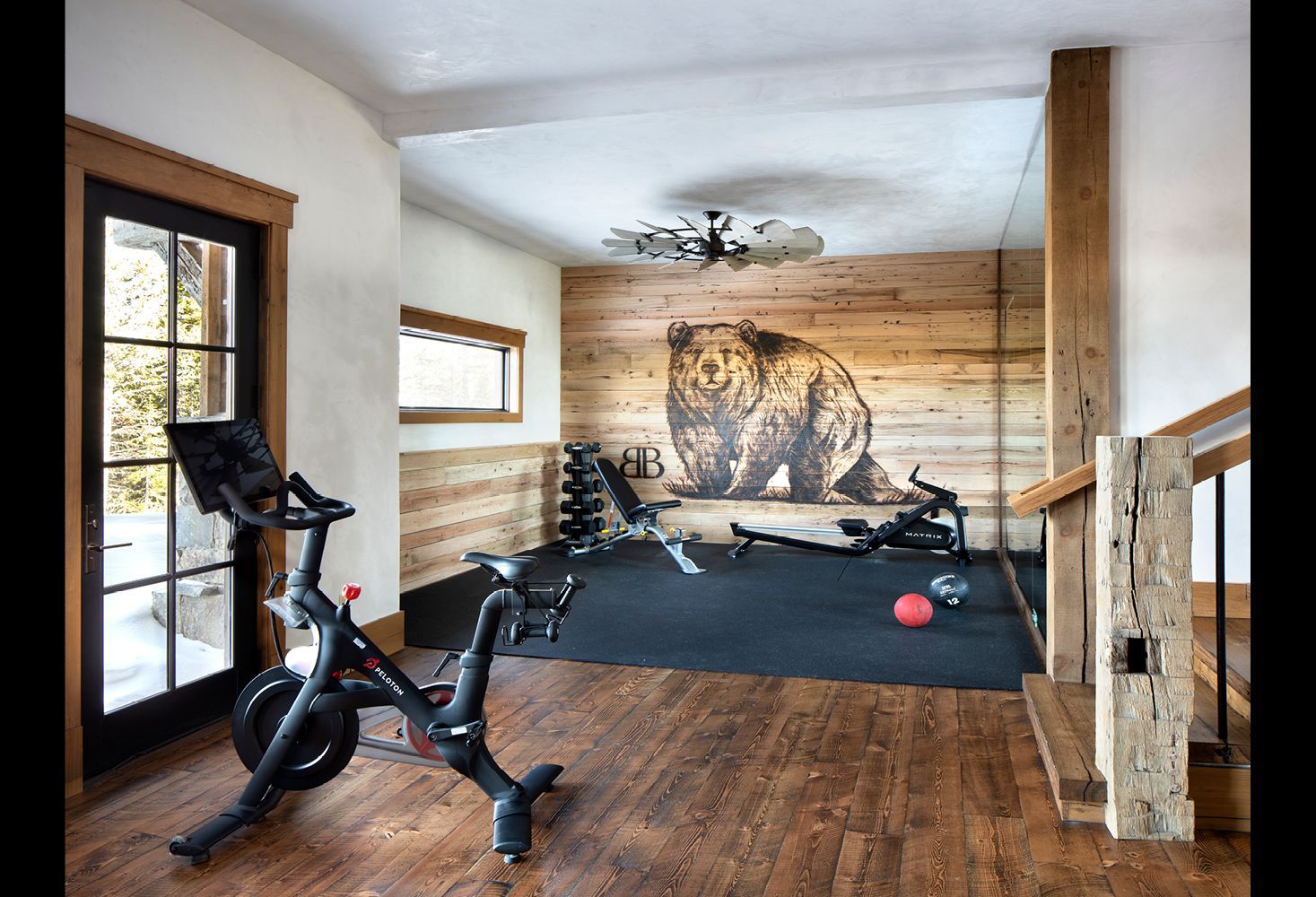 A home gym with a bike and a painting of a bear on the wall.
