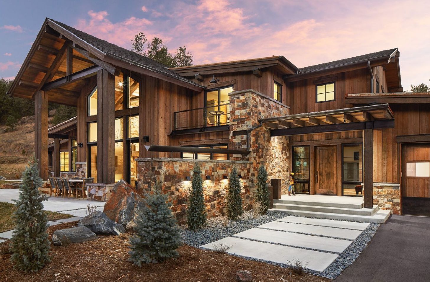 A large wooden house with a lot of windows is sitting on top of a hill.