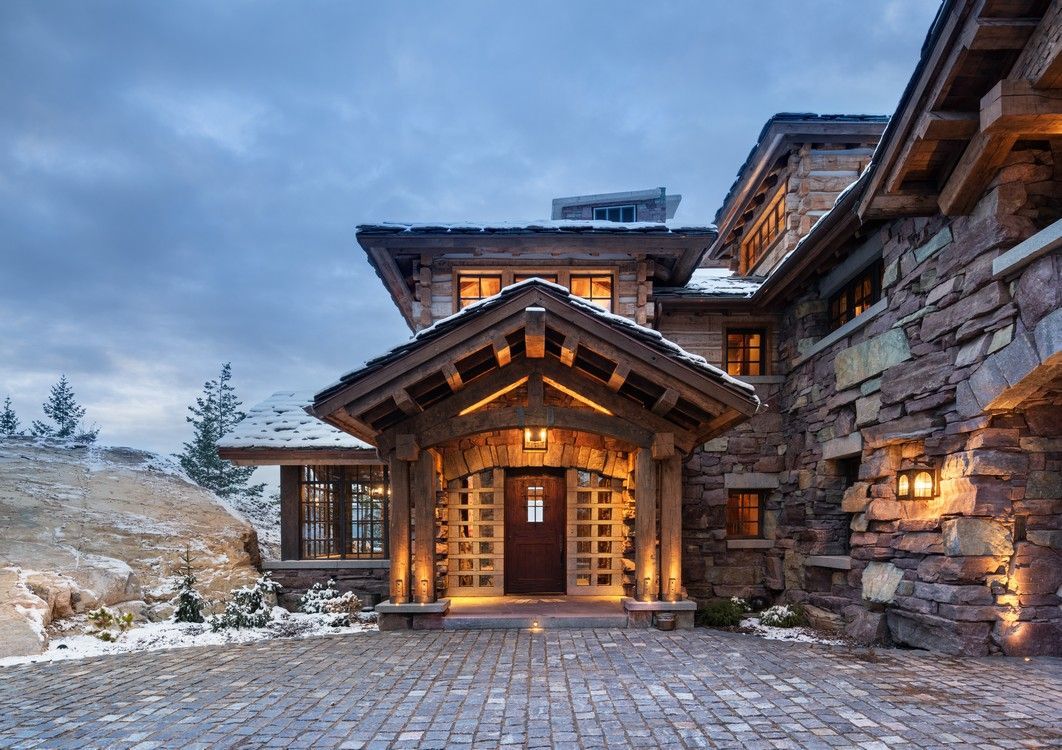 A large stone house with a driveway leading to it