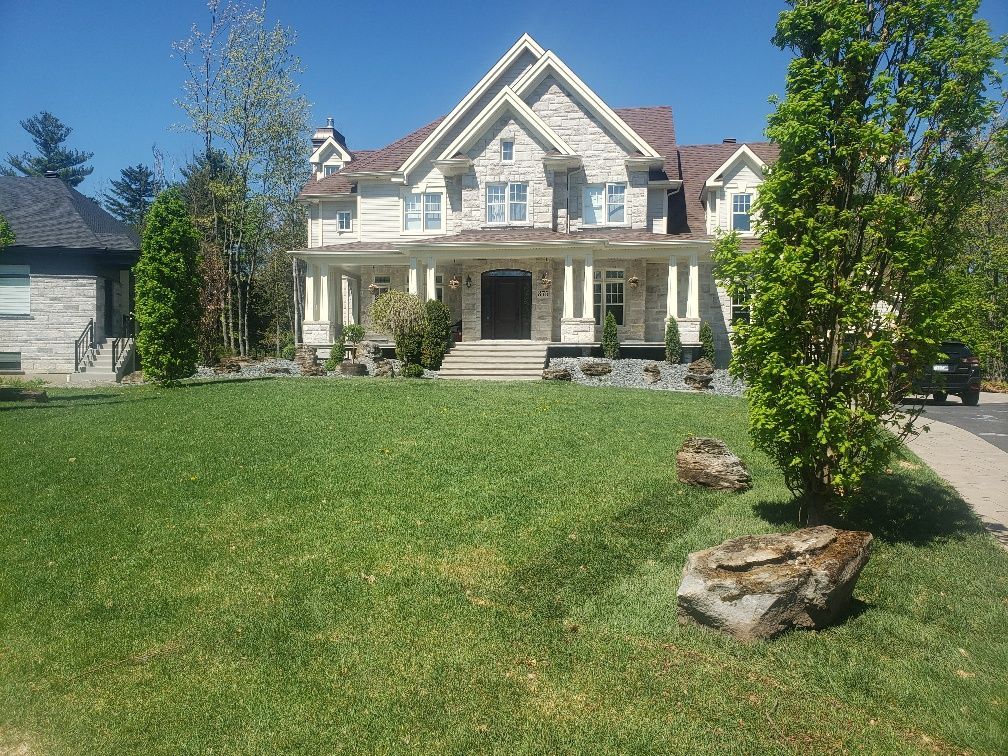 Une grande maison avec une grande pelouse devant elle