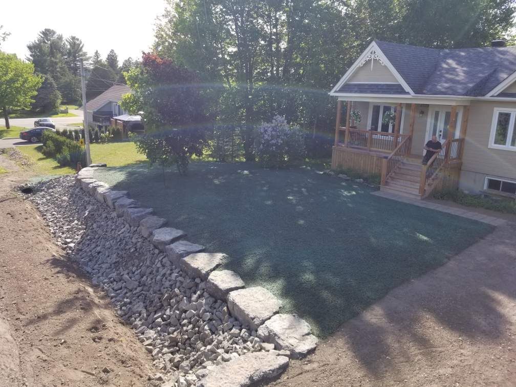 Une vue aérienne d'une maison avec une pelouse verte luxuriante