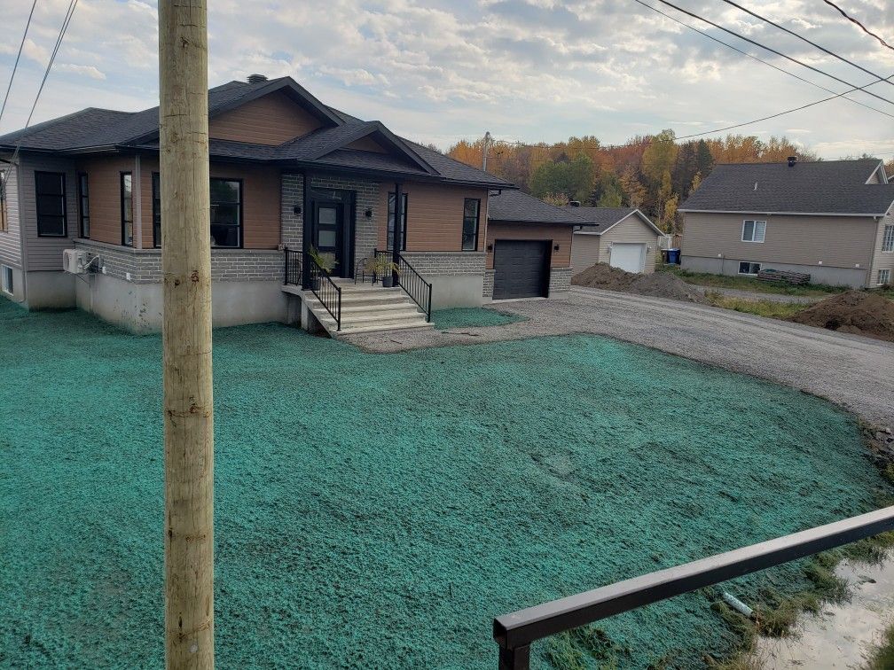 Une maison avec beaucoup d'herbe verte devant.