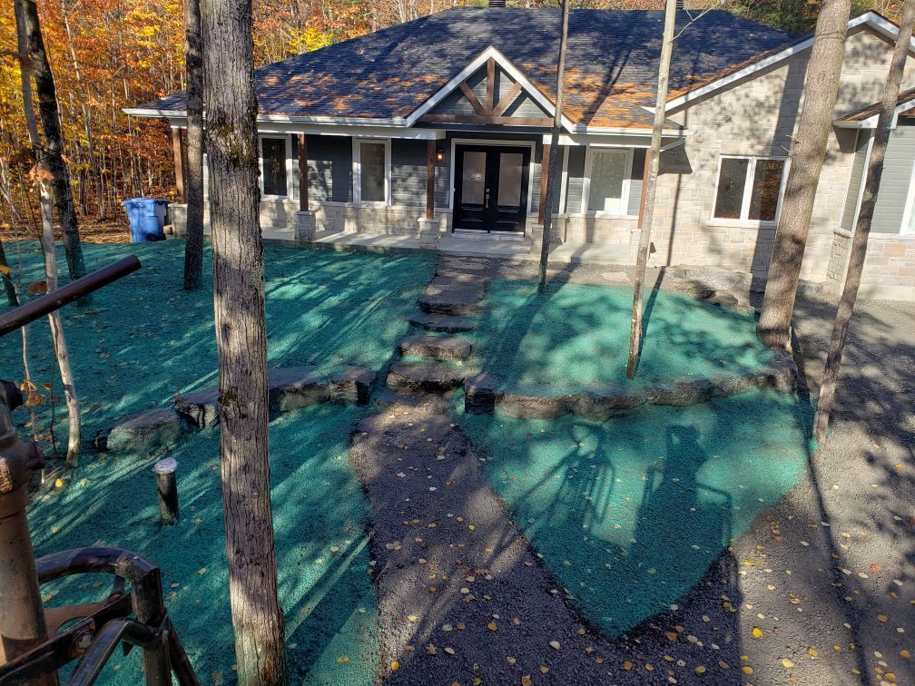 Une maison entourée d'arbres avec une pelouse verte devant elle