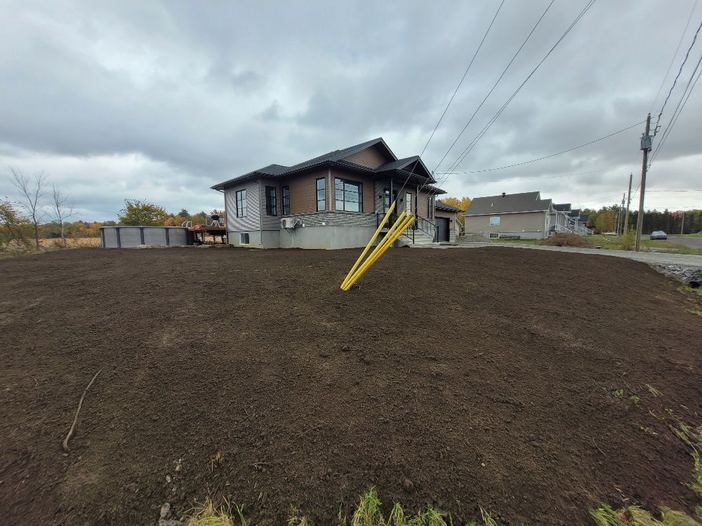 Une maison est assise au sommet d'une colline de terre.