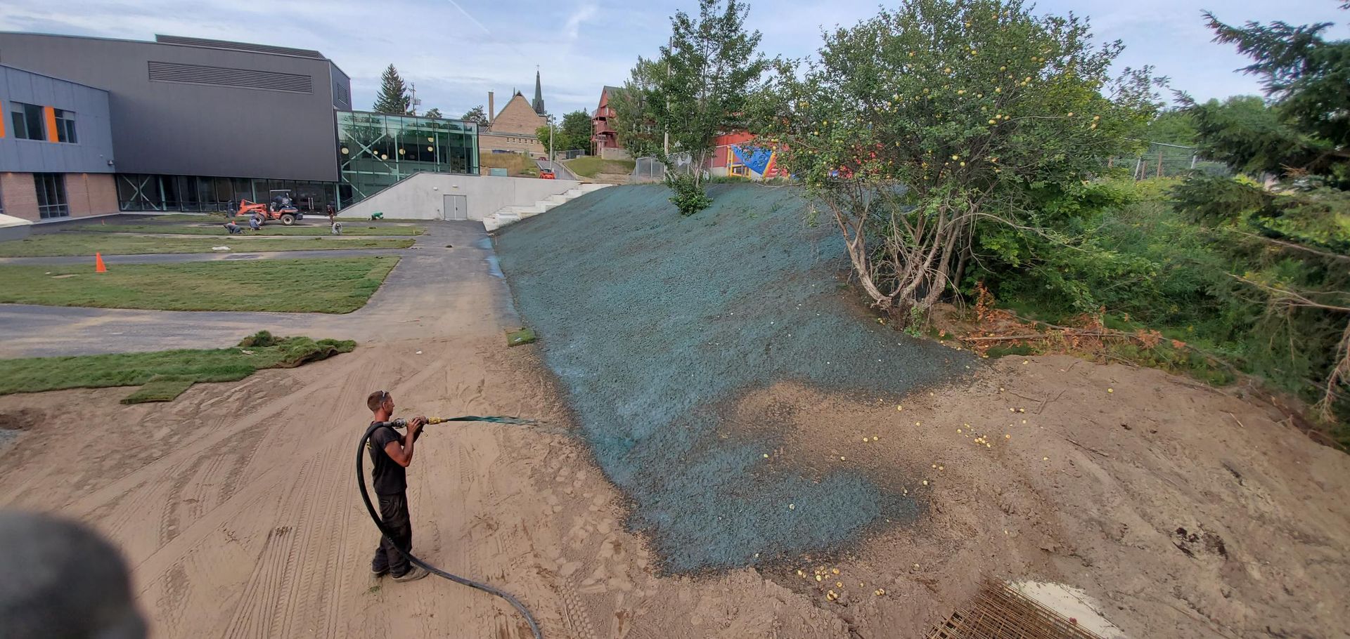 Un homme se tient devant un tas de gravier.