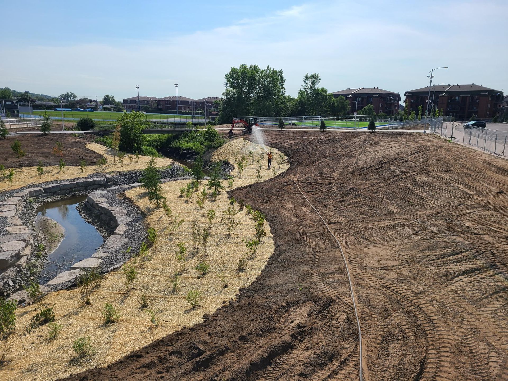 Un grand champ de terre avec un étang au milieu.