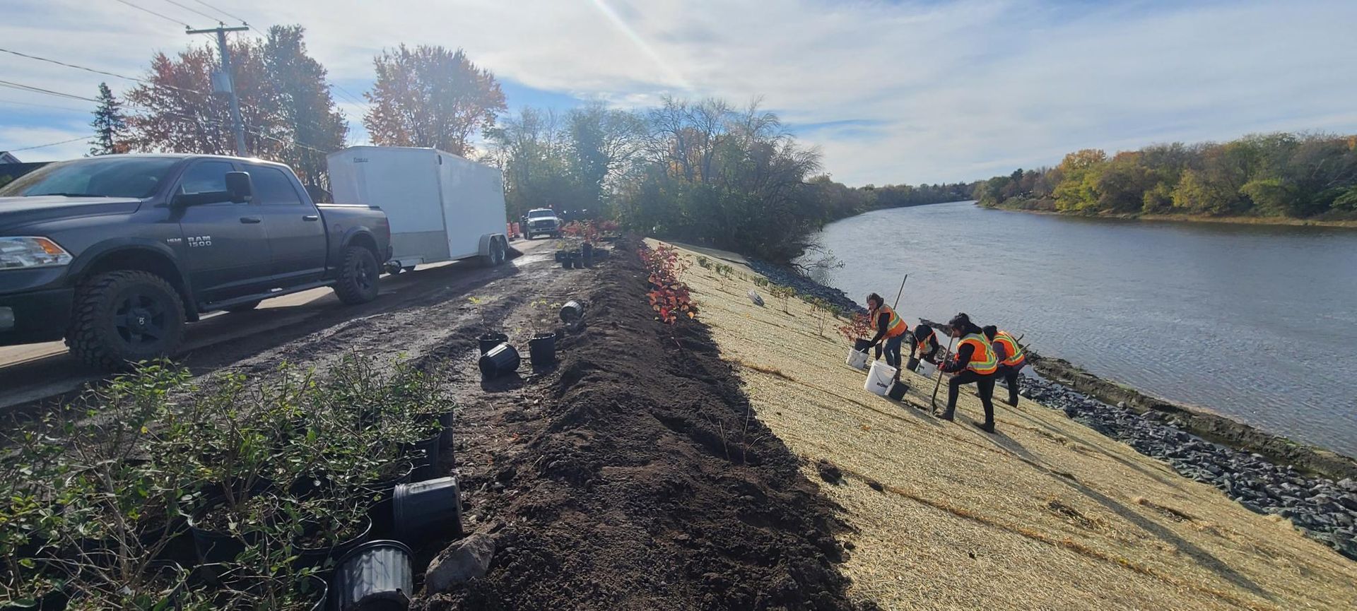 Un camion est garé sur le bord de la route à côté d'une rivière.