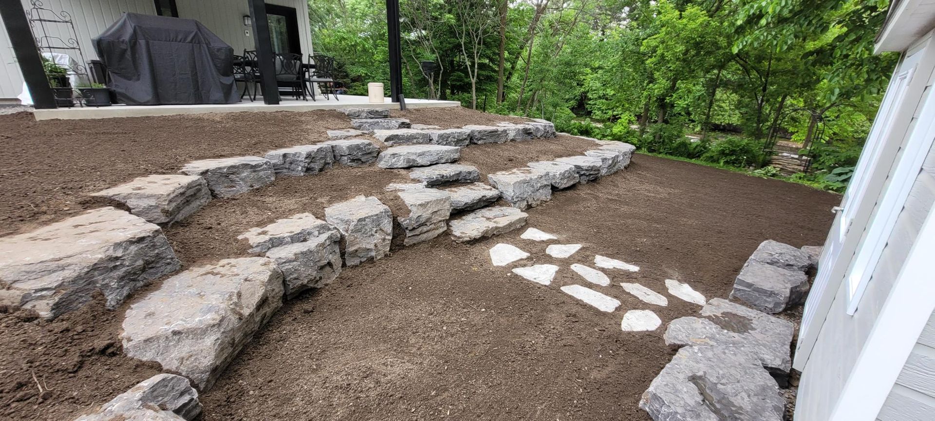 Une allée en pierre est en cours de construction dans l'arrière-cour d'une maison.