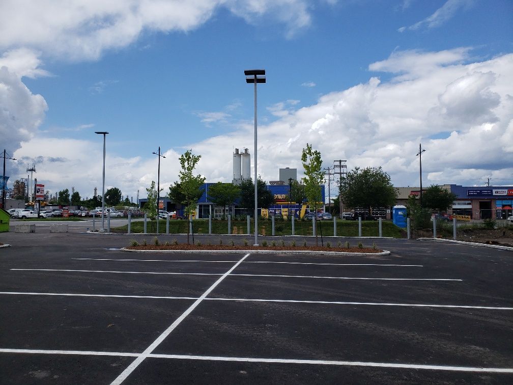 Un parking vide avec un bâtiment bleu en arrière-plan