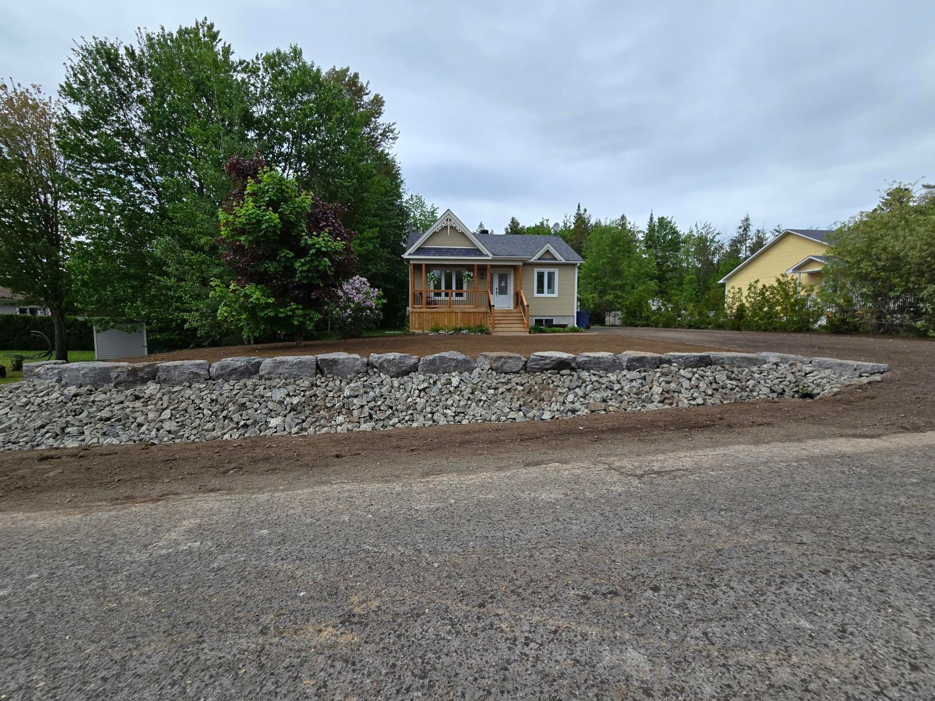 Une petite maison se trouve au milieu d'un terrain en gravier
