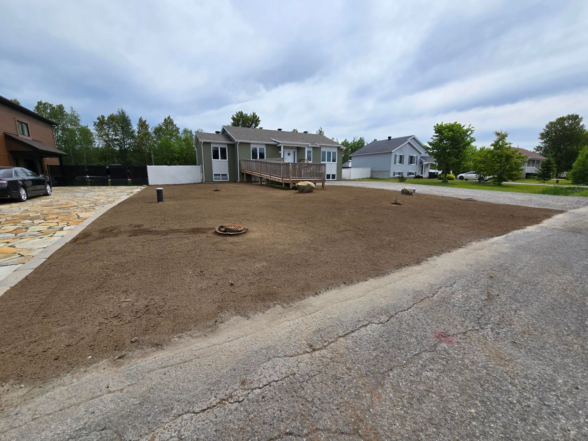 Un quartier résidentiel avec beaucoup de terre et une maison en arrière-plan