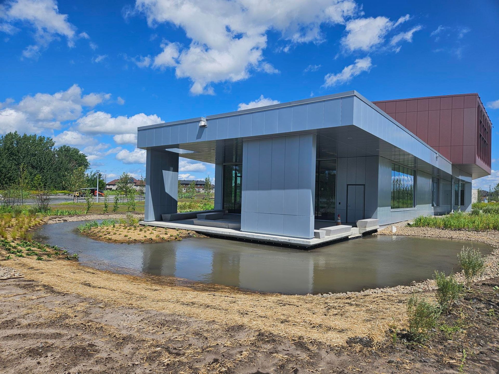 Un grand bâtiment avec un étang devant.