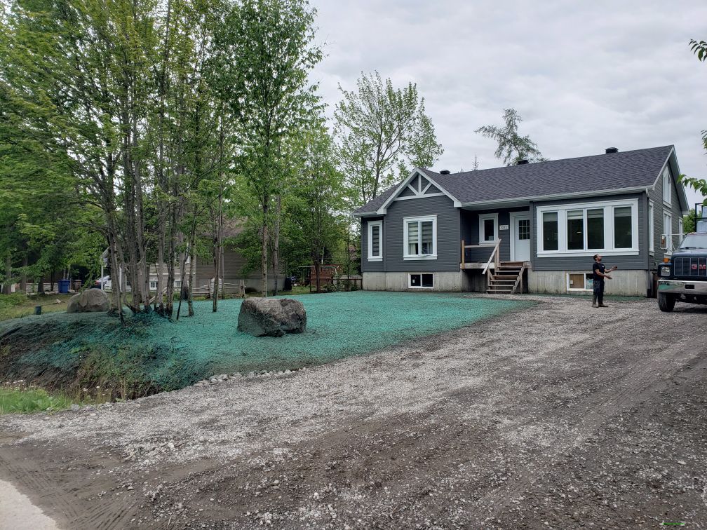 Une maison avec un camion garé devant.