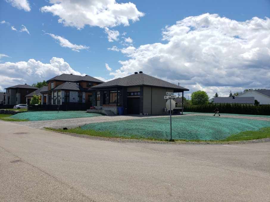 Une maison est située au coin d'une rue dans un quartier résidentiel.